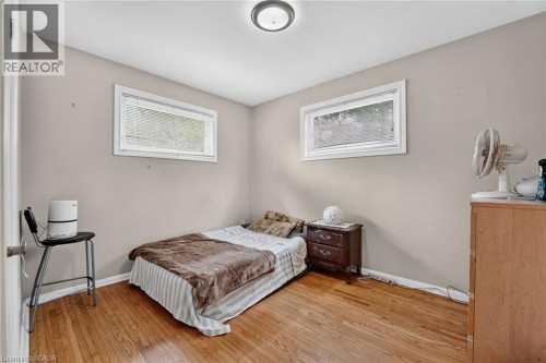 Hardwood flooring, light gray wall paint, two horizontal windows, and a flush mount ceiling light fixture - 121 Panin Road, Burlington, ON 