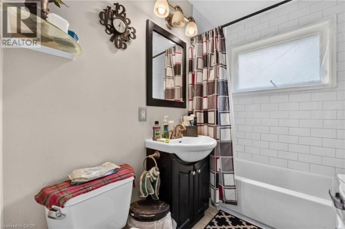 White subway tile shower surround, built-in bathtub, and a dark wood-finish vanity - 121 Panin Road, Burlington, ON 