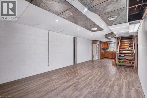 Expansive open area with wood-finish flooring, white block walls, and recessed lighting - 121 Panin Road, Burlington, ON 