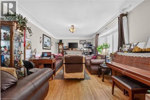 Hardwood-style flooring extends throughout, complemented by crown molding and a prominent bay window with plantation shutters - 121 Panin Road, Burlington, ON 