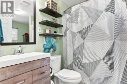 Bathroom featuring a wood-finish vanity with a white countertop and rectangular basin - 