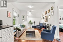 Hardwood-style flooring, white walls, recessed lighting, and a built-in cabinet with a dark countertop - 