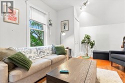 Hardwood-style flooring, white walls, angled ceiling, and track lighting fixture - 