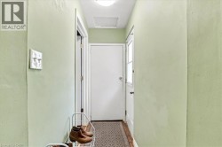 Hallway featuring light green wall paint and a patterned floor runner - 
