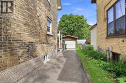 Exterior brick facade with a detached garage and paved driveway - 