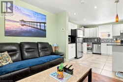 Recessed lighting, tile flooring, white cabinetry, stainless steel appliances, and a tiled backsplash - 