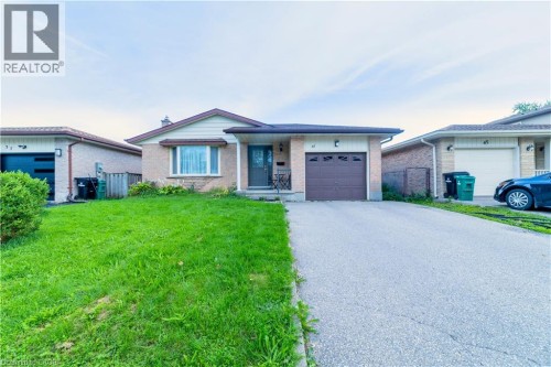 Brick facade with a contrasting front garage, paved driveway, and established front lawn - 41 Tuerr Drive, Kitchener, ON 