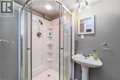 Corner shower enclosure with clear glass panels, chrome fixtures, and built-in shelving - 41 Tuerr Drive, Kitchener, ON 
