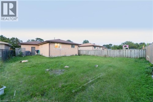 Expansive grass lawn bordered by a wood fence - 41 Tuerr Drive, Kitchener, ON 