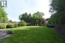 Expansive backyard featuring a large lawn, mature trees, wood privacy fencing, a wood deck with steps - 945 Glen View Avenue, Burlington, ON 