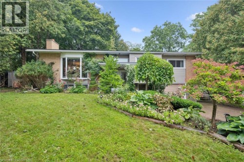 Brick and siding exterior with a prominent bay window, mature landscaping, and a well-maintained lawn - 100 Forest Hill Drive, Kitchener, ON 