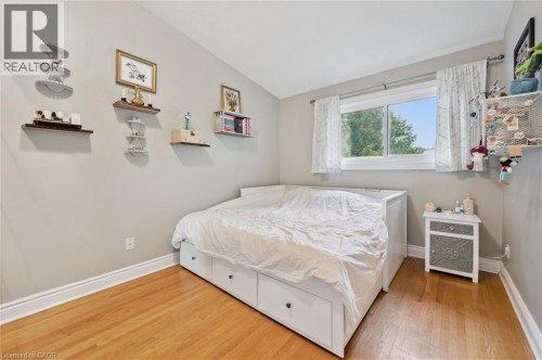 Hardwood flooring, light-toned wall paint, white trim, and a window with natural light - 100 Forest Hill Drive, Kitchener, ON 
