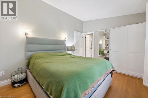 Light wood-finish flooring, two panel doors, built-in shelving, and white sliding closet doors - 100 Forest Hill Drive, Kitchener, ON 