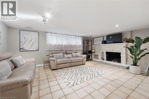 Tiled flooring throughout, recessed lighting, and a white brick fireplace with a hearth - 100 Forest Hill Drive, Kitchener, ON 