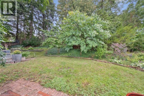 Expansive grassy area with a brick patio and tiered landscaping - 100 Forest Hill Drive, Kitchener, ON 