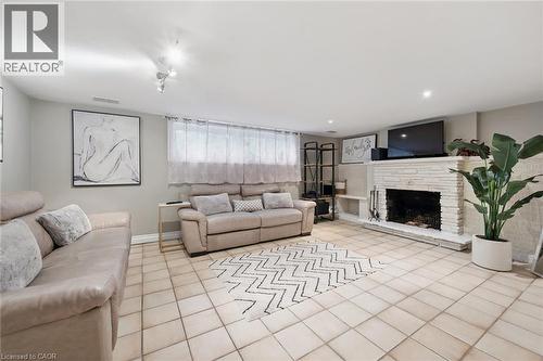 Tiled flooring throughout, recessed lighting, and a white brick fireplace with a hearth - 100 Forest Hill Drive, Kitchener, ON 