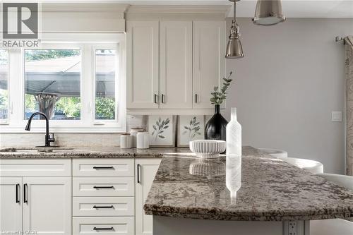 Kitchen featuring white shaker-style cabinetry with dark hardware, granite countertops, an undermount sink with a matte black faucet, and a multi-paned window - 20 San Marino Crescent, Hamilton, ON 