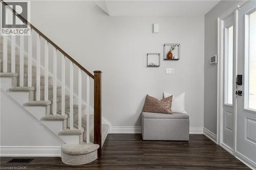 Entryway featuring wood-finish flooring and a carpeted staircase with white risers and a dark wood handrail - 20 San Marino Crescent, Hamilton, ON 