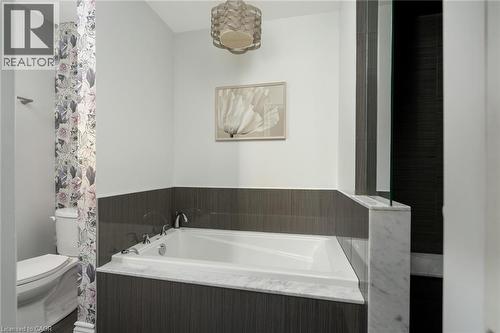 Built-in soaking tub with deck-mounted faucet and marble surround - 20 San Marino Crescent, Hamilton, ON 
