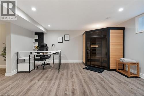 Dedicated space featuring a built-in sauna with glass and wood paneling, wood-finish flooring, recessed lighting, and a window - 20 San Marino Crescent, Hamilton, ON 