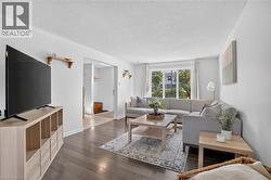 Laminate flooring, white wall finishes, and a large window providing ample natural light - 