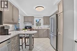Kitchen with ample cabinetry, stainless steel appliances, tile flooring, and a built-in breakfast bar - 