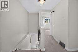 Carpeted hallway with painted walls and a flush-mount ceiling light - 