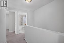 Well-lit hallway with neutral wall tones and textured ceiling - 