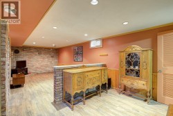 Recessed lighting, wood-finish flooring, exposed brick accent wall, wainscoting, and a built-in partial wall - 
