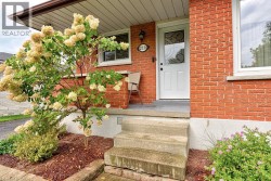 Brick exterior with white trim, concrete steps, and a covered entry - 