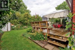 Expansive backyard featuring a wood deck, built-in benches, and garden beds - 