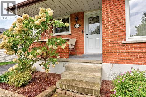 Brick exterior with white trim, concrete steps, and a covered entry - 210 Shelley Drive, Kitchener, ON 