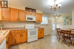 Wood cabinetry, tile backsplash, built-in microwave and ceiling fan - 