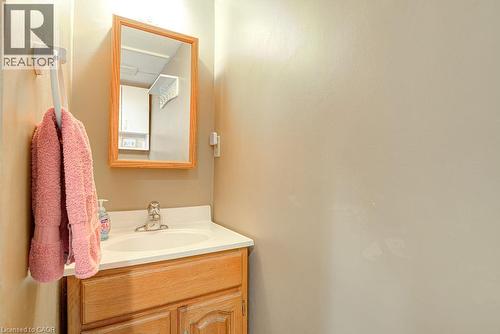 Vanity with wood-finish cabinetry, integrated sink, and chrome-finish faucet - 210 Shelley Drive, Kitchener, ON 