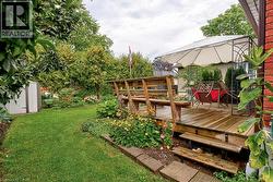 Expansive backyard featuring a wood deck, built-in benches, and garden beds - 