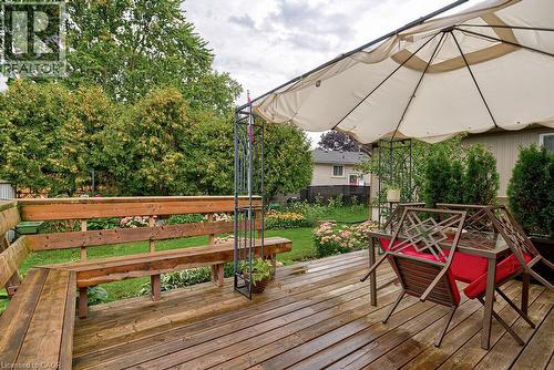 Wood deck with built-in bench, lush landscaping, and mature trees - 210 Shelley Drive, Kitchener, ON 