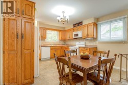 Kitchen featuring wood cabinetry, white appliances, a tile backsplash - 