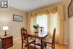 Hardwood flooring, neutral wall color, large window with elegant drapery - 