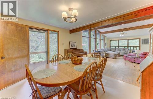 Open-concept living space with exposed wood beams, extensive window banks, and wood-finish flooring - 80 Chapel Hill Drive, Kitchener, ON 