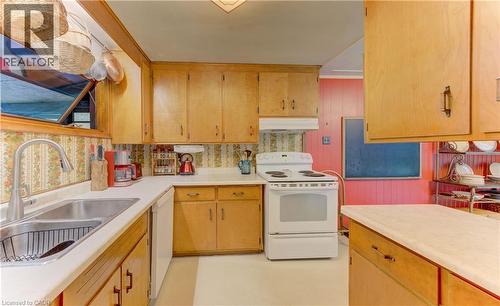 Kitchen featuring light wood cabinetry, white countertops, a double basin stainless steel sink with a high-arc faucet, and a white electric range with an overhead hood - 80 Chapel Hill Drive, Kitchener, ON 