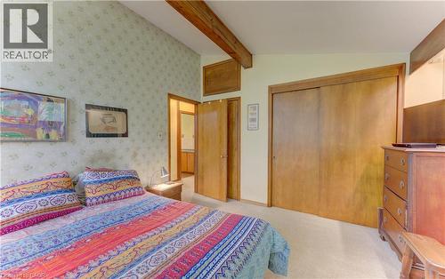 Vaulted ceiling with exposed wood beams, wood-finish sliding closet doors, and light-toned wall-to-wall carpeting - 80 Chapel Hill Drive, Kitchener, ON 