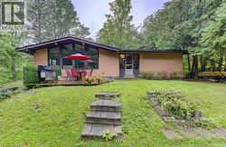 Expansive yard with mature trees, stone steps, and a multi-level deck - 