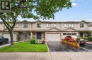 Brick exterior with dormer windows, attached garage, and paved driveway - 1261 Stephenson Drive, Burlington, ON 