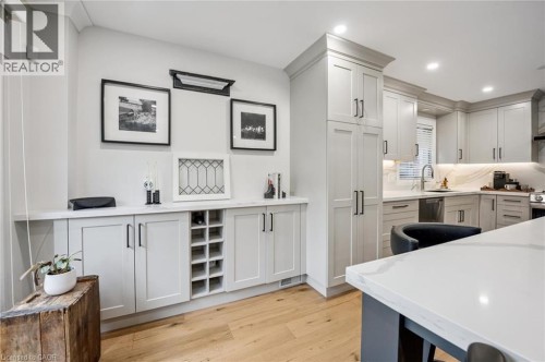Light-toned wood-finish flooring complements custom cabinetry with black hardware - 1261 Stephenson Drive, Burlington, ON 