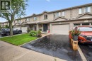Brick exterior, attached garage, paved driveway, mature tree, and landscaped garden beds - 1261 Stephenson Drive, Burlington, ON 