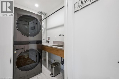 Stacked laundry appliances, built-in utility sink, and wood-finish countertop - 1261 Stephenson Drive, Burlington, ON 