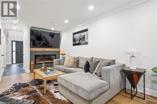 Recessed lighting, wood-finish flooring, and a contemporary fireplace with a wood mantel - 1261 Stephenson Drive, Burlington, ON 
