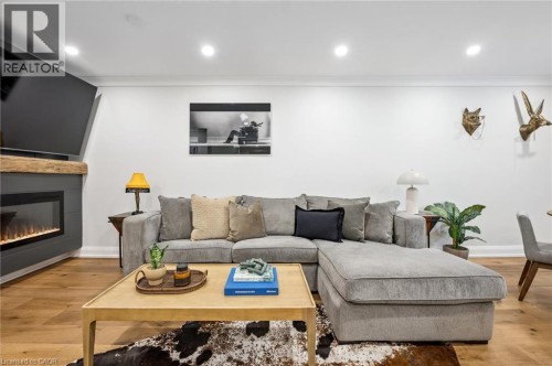 Hardwood flooring, crown molding, recessed lighting, and a modern fireplace with a wooden mantel - 1261 Stephenson Drive, Burlington, ON 