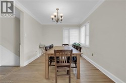 Dining room featuring a chandelier, crown molding, light wood finished floors, and baseboards - 