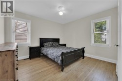 Bedroom with baseboards, light wood-style flooring, and a ceiling fan - 